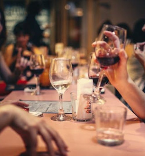 A lively scene of friends enjoying wine and conversation in a cozy bar setting.